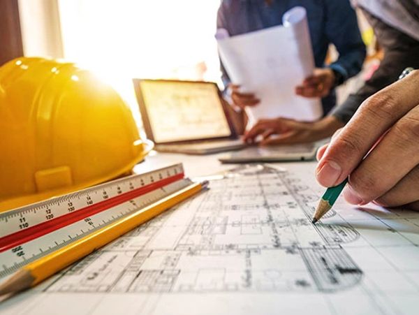 Architects working on building plans with tools and blueprints.