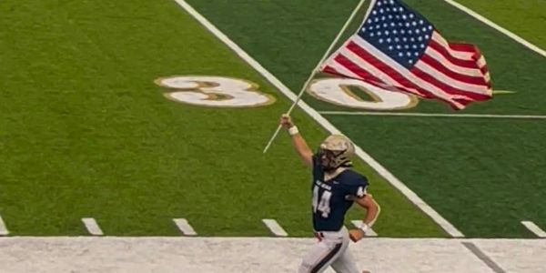 Football player running with an American flag.