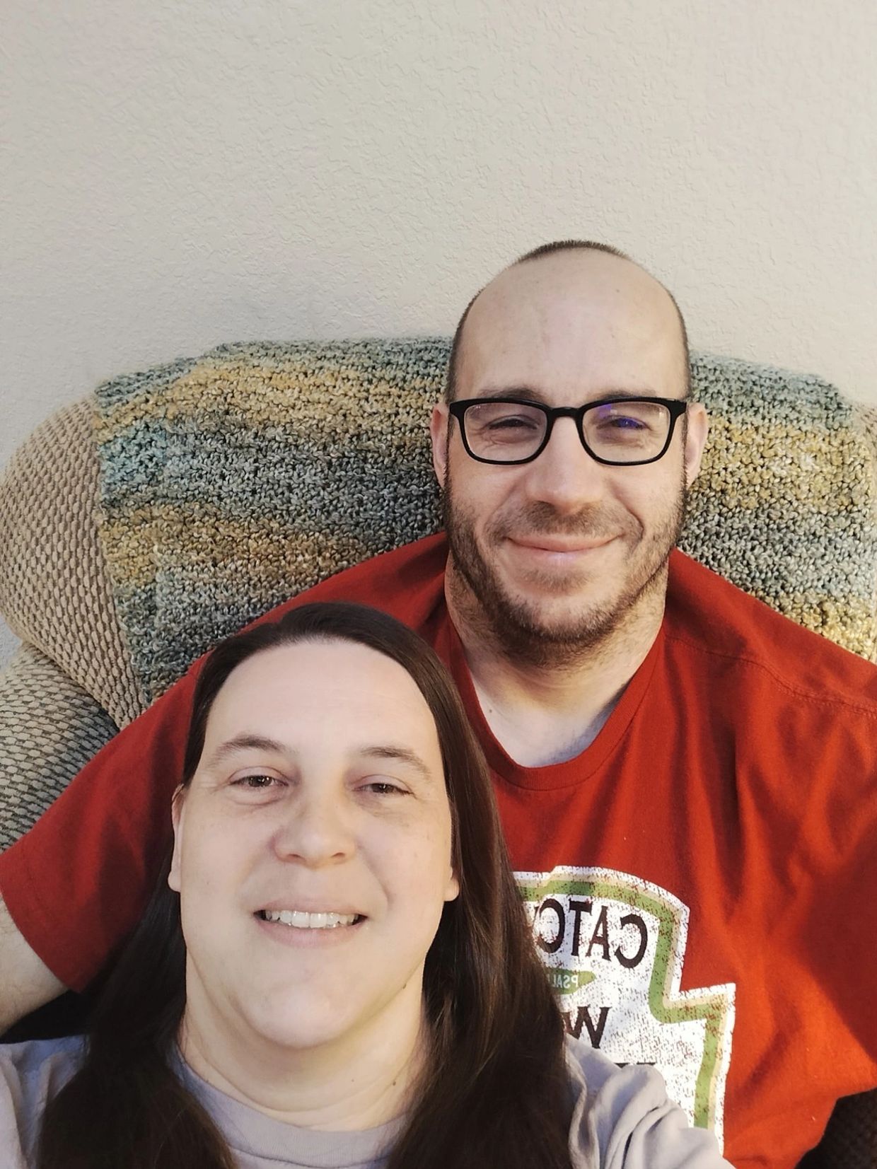 Smiling couple sitting together on a chair.