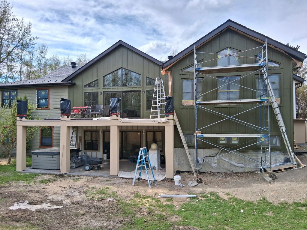 House exterior undergoing renovation with scaffolding and ladders.