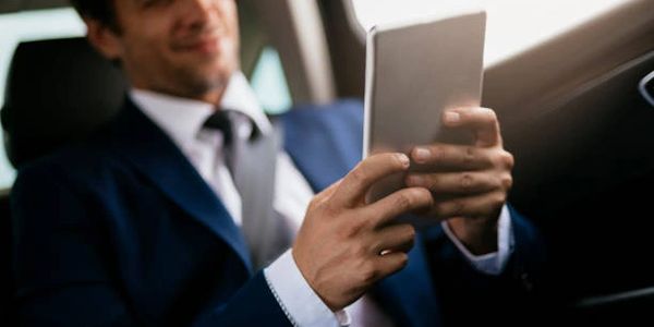 a businessman sitting in a luxurious limousine while at houston airport waiting for departure