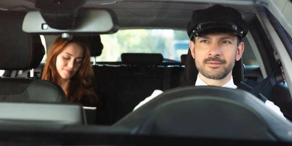 A business woman communicating with the chauffeur while in a limousine in front of Houston Airport