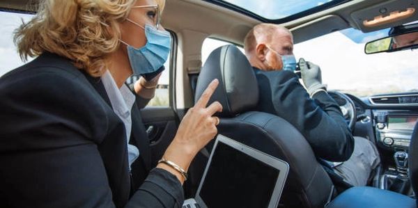 a business woman customizing her ride while in a limousine in front of houston airport