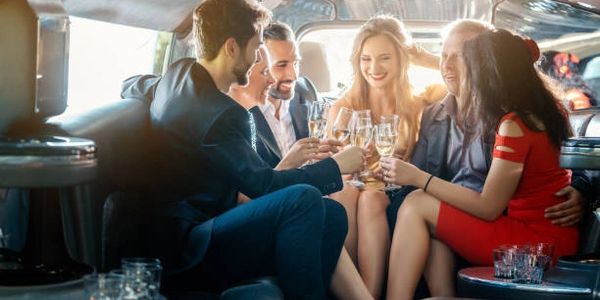 a group of friends drinking champagne while in a limousine at houston airport