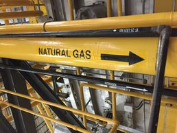 Natural gas piping painted yellow and marked effectively with labels at an industrial site.
