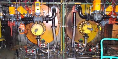 Two industrial scroll type burners at a major steel facility boiler for consuming blast furnace gas.