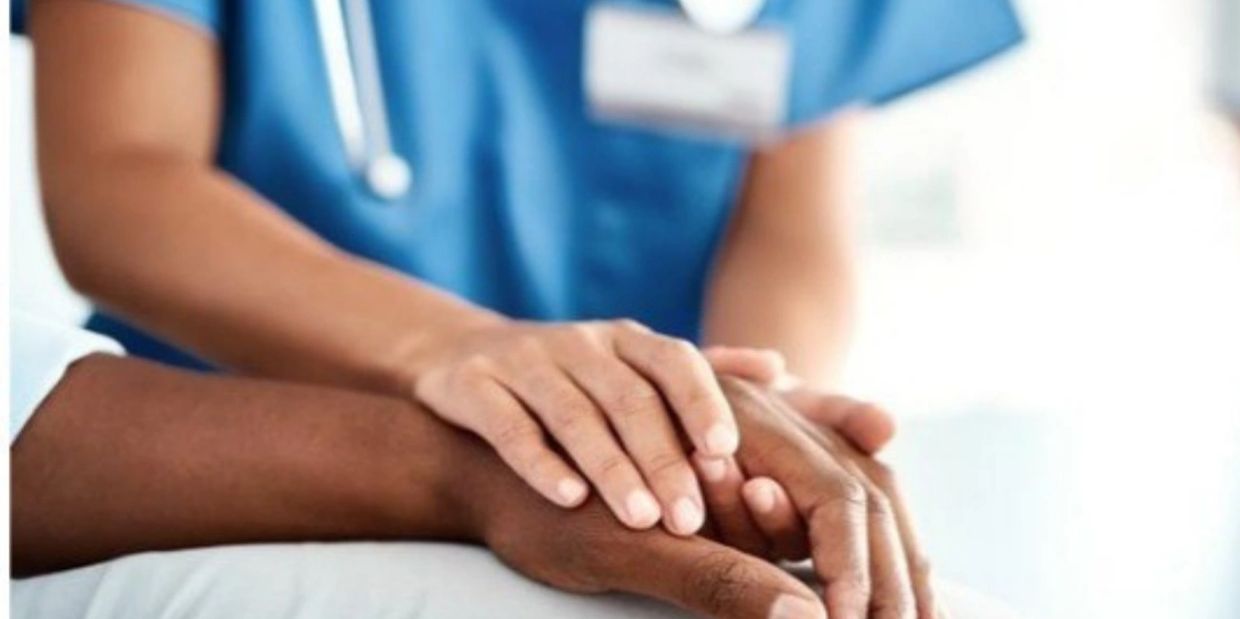 A nurse holding a patient’s hand