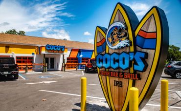 Exterior view of Coco's Surf Bar & Grill with colorful signage.