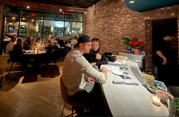 Couple sitting at a bar in a cozy restaurant.
