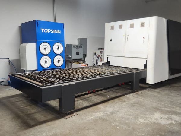 Industrial laser cutting machine with a TOPSINN filtration system in a workshop.