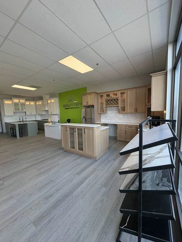 Modern kitchen showroom with various countertops and cabinetry displays.