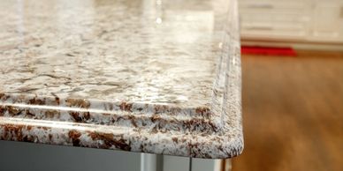 Close-up of a polished granite countertop edge in a kitchen.