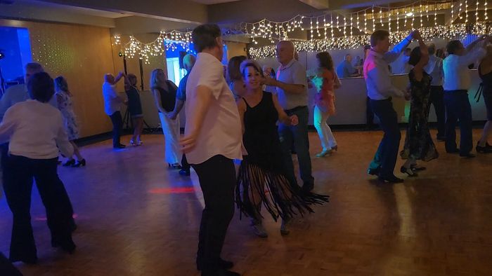 People enjoying a lively dance party with string lights.