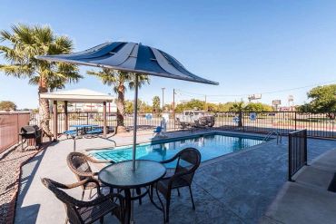 Outdoor pool area with table and umbrella.