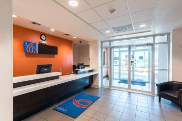 Reception area of a Motel 6 with a modern desk and entrance.