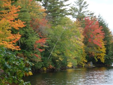 Colorful fall foliage stretches out over Upper Baker Pond in East Orford, NH