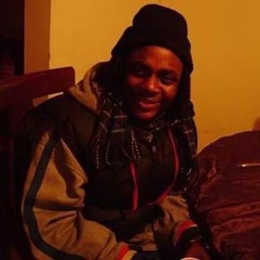 A man wearing jacket and sitting on the chair