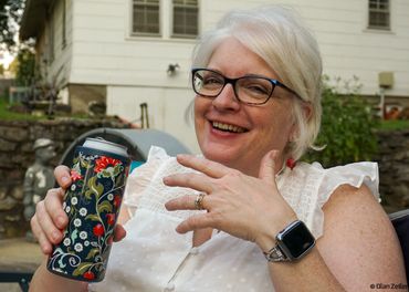 Woman laughing with drink in right hand