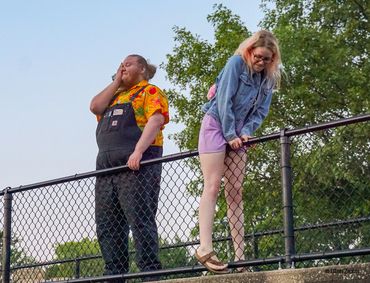 Man being embarrassed as girl climbs over bridge railing