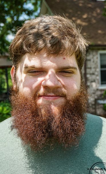 Bearded man with leafy shadow across face