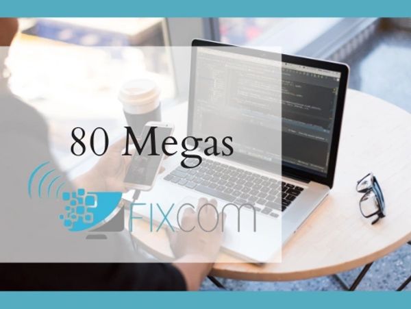 Person using laptop and phone with 80 Megas Fixcom internet speed advertisement.