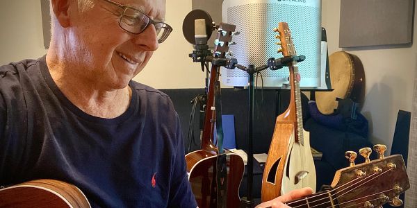 Man playing guitar in a music room.
