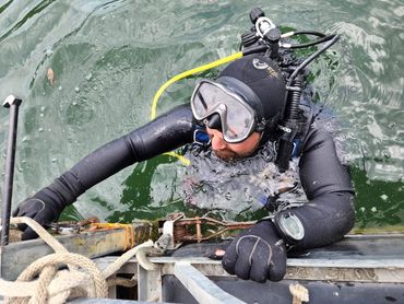 scuba diver in the water fixing a dock