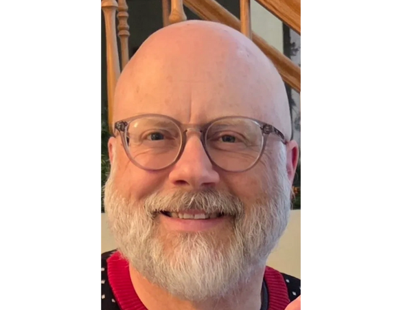 Smiling bald man with glasses and a white beard.