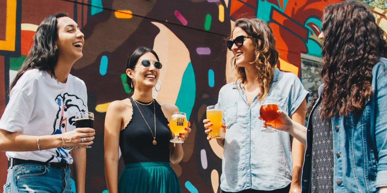 Women in front of a mural, brewery tastings, and brewery tours, during Wynwood Brewery and Art Tour.