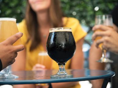 People standing in front of a table, each holding a beer during the Miami Beach Brewery Tour.