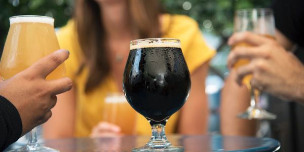 People standing in front of a table, each holding a beer during the Miami Beach Brewery Tour.