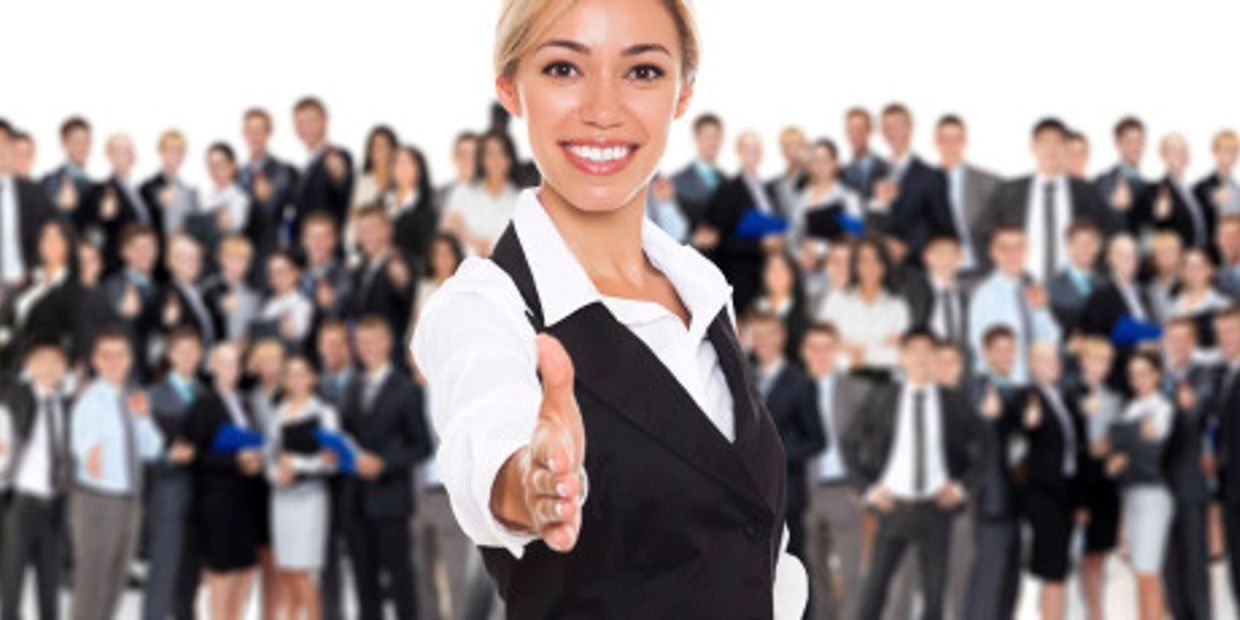A woman standing confidently in front of a crowd of employees, cruise line staffing