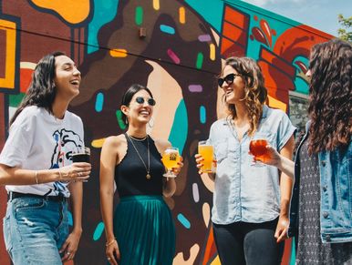 Women in front of a mural, brewery tastings, and brewery tours, during Wynwood Brewery and Art Tour.