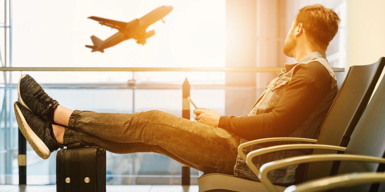 Traveler waiting at airport gate gazing at a plane taking off, shuttle