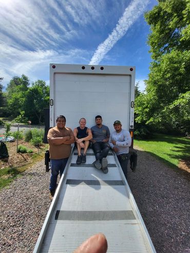 4 crew members sitting behind a truck