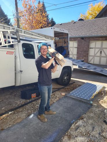 Worker carrying crown moulding out of home