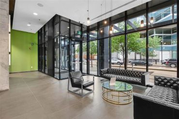 Modern lobby with black leather couches and glass walls.