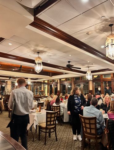 Busy restaurant with diners and warm lighting.