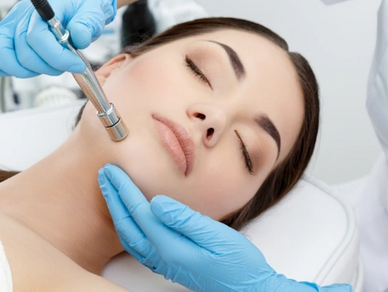 Microdermabrasion is being performed on a woman.