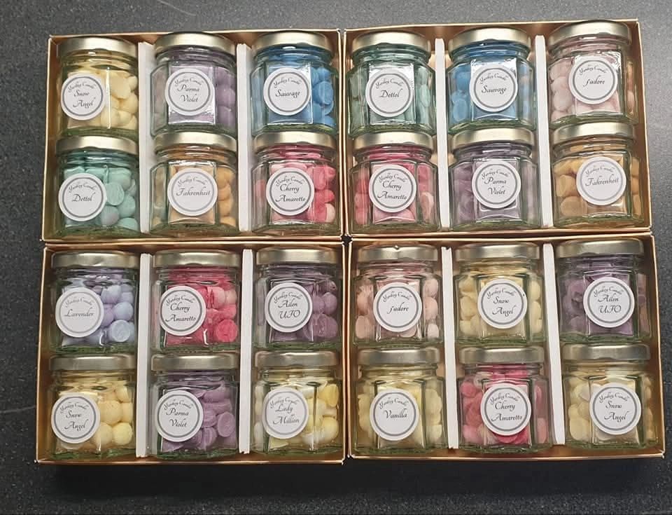 Four boxes of assorted colorful candy jars with various flavors.
