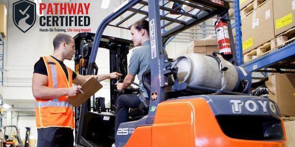 Instructor training a woman on forklift operation in a warehouse.