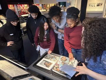 A group of people looking at historical photographs in a museum.