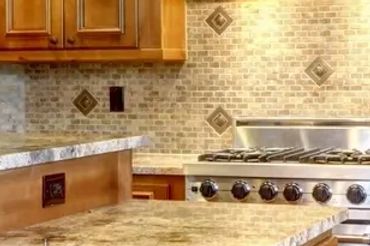 Spacious kitchen with wooden cabinetry and granite countertops.