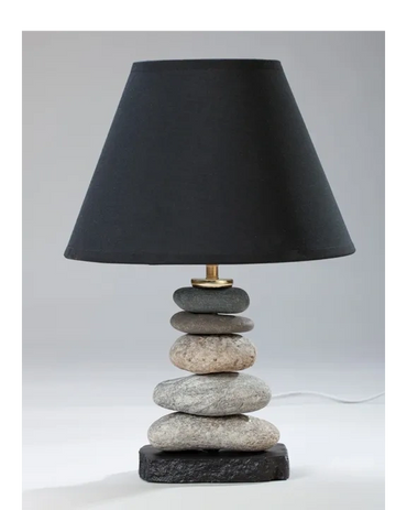 Table lamp with stacked stone base and black lampshade.