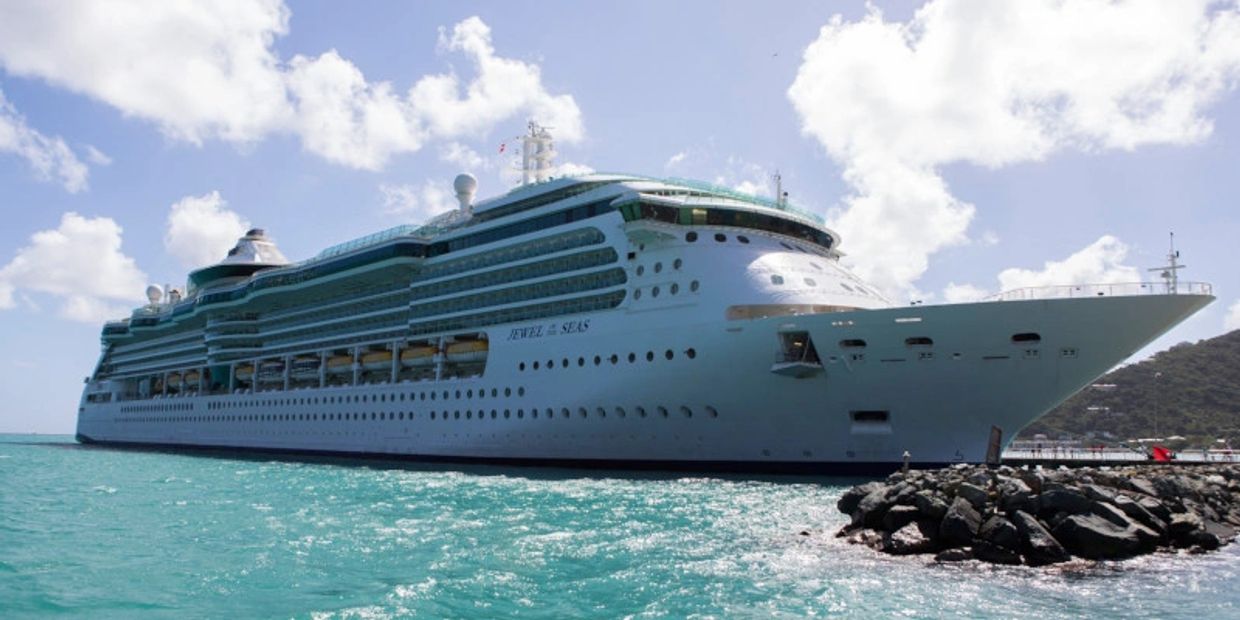 Large cruise ship Jewel of the Seas docked on a sunny day.