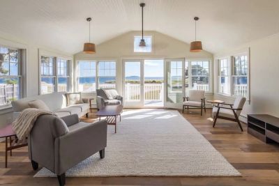 Bright living room with ocean view through large windows.
