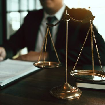 Scales Of justice, man in background, reading a report