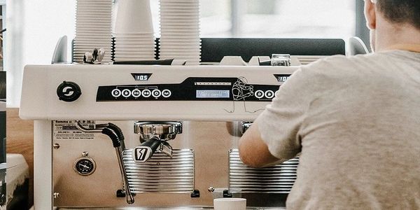 Barista preparing coffee using a professional espresso machine.