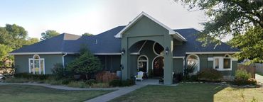 Stucco exterior, arched windows, circular entry window and angled walls.