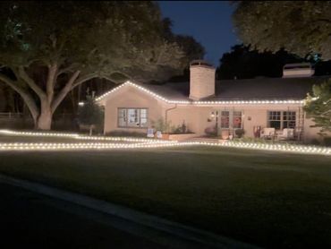A house decorated with white string lights at night.